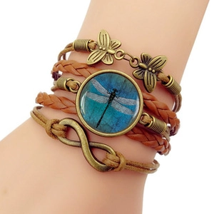 Detail of multi-layer leather bracelet with dragonfly glass charm and bronze butterfly