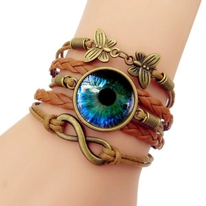 Detail of multi-layer leather bracelet with bronze butterfly and blue iris glass charm