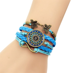 Détail d'un bracelet bohème multicouche avec symbole infini et breloque mandala