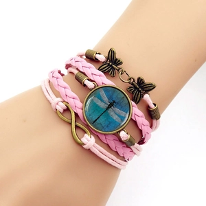 Close-up of pink braided multi-layer bracelet with infinity symbol and dragonfly charm