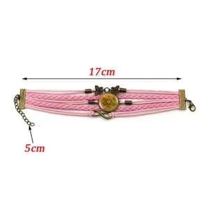 Detail of pink layered leather bracelet with Metatron's Cube gem and butterfly charms