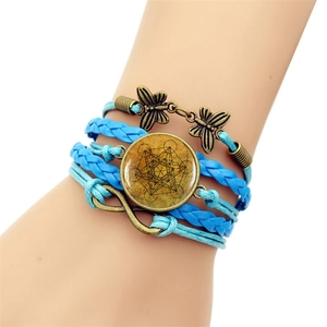 Detail of multi-layer woven Metatron's Cube bracelet with blue wax cords and bronze butterfly