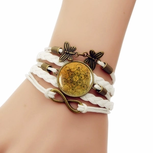 Detail of multi-layer wrap bracelet featuring butterfly charms and Metatron Cube gem