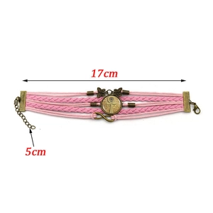 Detail of pink multilayer braided leather bracelet with bronze ankh and butterfly charms