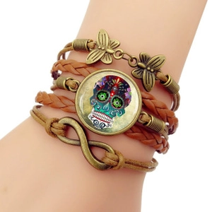Détail du bracelet multicouche en cuir tressé avec cabochon tête de mort et symbole infini