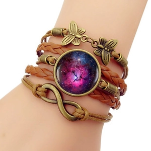 Détail du bracelet multicouche en cuir tressé avec pendentif galaxie en verre violet