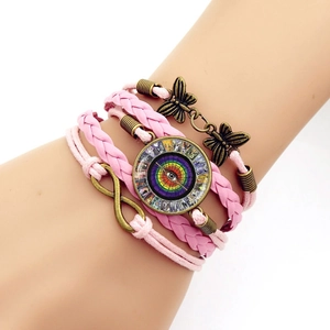 Bohemian multilayer pink woven bracelet with butterfly and infinity symbol on a wrist