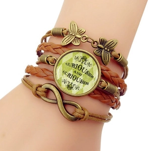 Detail of multi-layer leather bracelet with bronze butterfly charm and glass dome