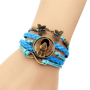 Détail d'un bracelet tissé multicouche avec breloque scarabée égyptien et symbole de l'infini