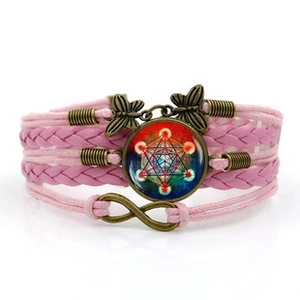 Detail of pink woven bracelet with butterfly charms and Metatron Cube glass pendant