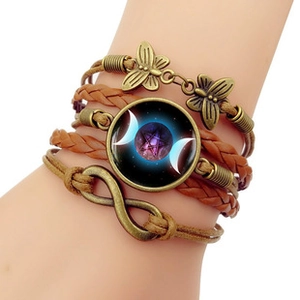 Detail of vintage layered leather bracelet with moon and star glass cabochon