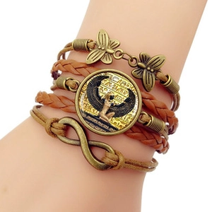Detailed close-up of multilayer leather bracelet featuring bronze butterfly and Egyptian charms