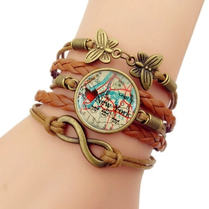 Detail of multi-layer woven leather bracelet featuring infinity charm and butterfly pendants