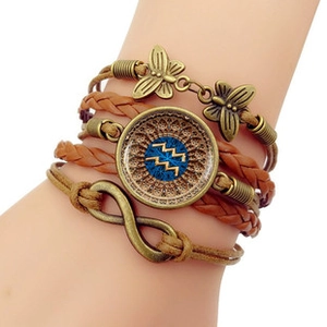 Detail of multi-layer leather bracelet with Aquarius zodiac glass cabochon and bronze butterfly