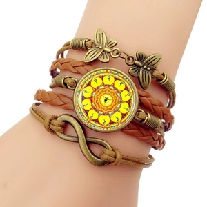 Detail of vintage layered bracelet with infinity symbol and butterfly charms on wrist