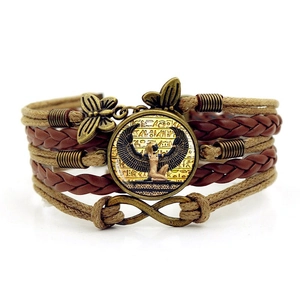 Detailed close-up of multilayer braided leather bracelet with Cleopatra glass pendant
