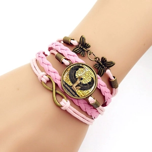 Close-up of pink layered leather bracelet featuring bronze infinity and butterfly charms