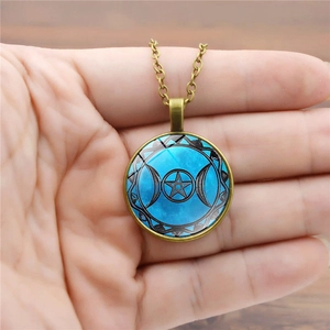 Vintage Triple Moon Goddess pendant necklace with pentagram on blue background