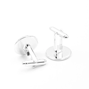 Detail view of silver round cufflinks with rotating T-shaped closures for formal shirts