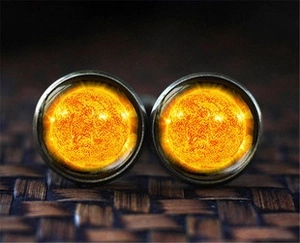 Detailed close-up of vintage bronze cufflinks featuring a yellow sunburst glass pattern