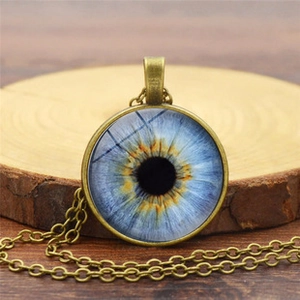 Dettaglio della collana con pendente occhio di Horus in bronzo antico e iride blu su legno