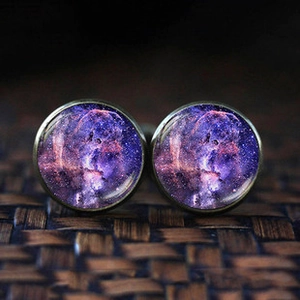 Detailed macro view of vintage bronze cufflinks with purple nebula art glass inlay