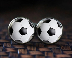 Detailed close-up of classic black and white soccer pattern glass dome cufflinks for men