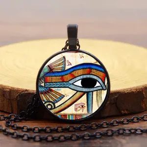 Collana vintage con ciondolo Occhio di Horus egiziano in vetro su superficie di legno
