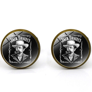 Macro view of vintage bronze cufflinks with Jack Daniel's logo under glass dome