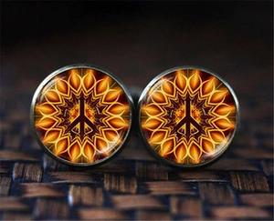 Macro view of vintage bronze cufflinks featuring a peace sign over a sunburst mandala