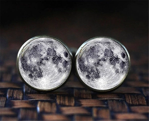 Detailed close-up of bronze cufflinks with moon surface patterns under glass cabochon