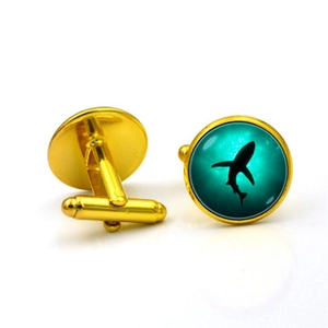 Detail of French shark silhouette cufflinks with golden alloy and teal ocean glass inlay