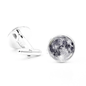 Macro detail of silver moon cufflinks with polished metal T-hinge and glass cabochon