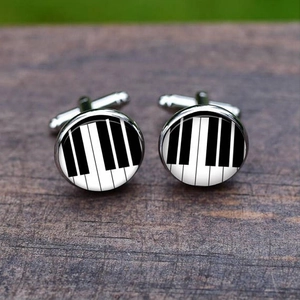 Detailed macro view of silver-tone cufflinks featuring a black and white piano key pattern