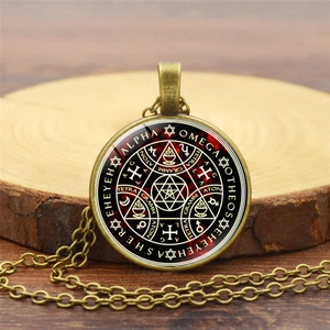 Detail of vintage Tree of Life glass pendant with mystical alchemy symbols and antique finish