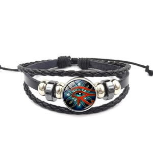 Détail du bracelet multicouche en cuir avec charm en verre de l'Oeil d'Horus et perles