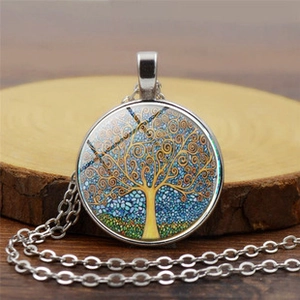 Detailed view of silver tree of life glass dome pendant necklace on wooden base