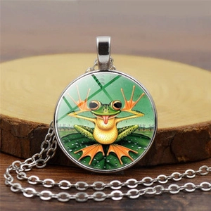 Detailed close-up of a vintage round glass frog pendant with an elegant silver chain