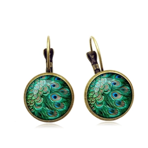Detailed macro view of lever-back earrings with bronze base and peacock feather pattern