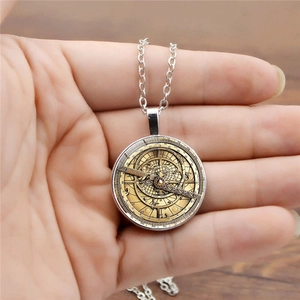 Macro view of vintage gold astrolabe pendant with silver chain and glass dome