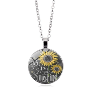 Detalle del colgante de cristal con girasol y frase You are my sunshine grabada