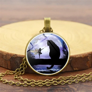 Vintage bronze necklace with black cat and winged fairy glass gem pendant on a wood surface