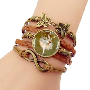 Détail d'un bracelet multicouche en cuir avec papillons en bronze et breloque ballerine