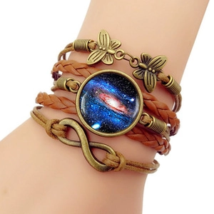 Détail du bracelet multicouche en cuir tressé avec charmes papillon et signe infini