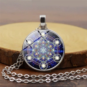 Vue macro d'un pendentif argenté avec géométrie sacrée sur une surface en bois