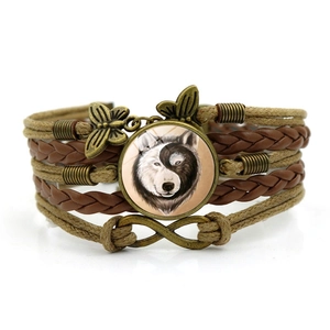 Détail du bracelet en cuir multicouche avec dôme en verre loup yin yang et papillon