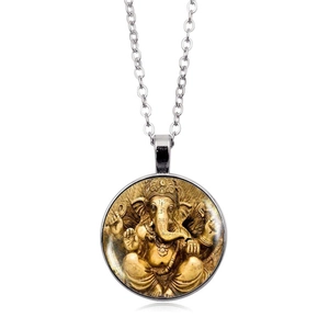 Vue détaillée du pendentif Ganesha argenté avec verre bombé et image dorée à l'intérieur