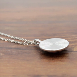 Silver Northern Lights glass pendant necklace with radial texture on wooden background