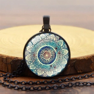 Detalle del collar mandala yoga con colgante de cristal azul sobre fondo de madera