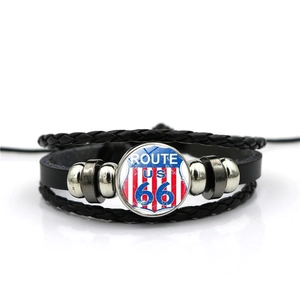 Vue macro du médaillon Route 66 sur un bracelet multicouche en cuir noir tressé